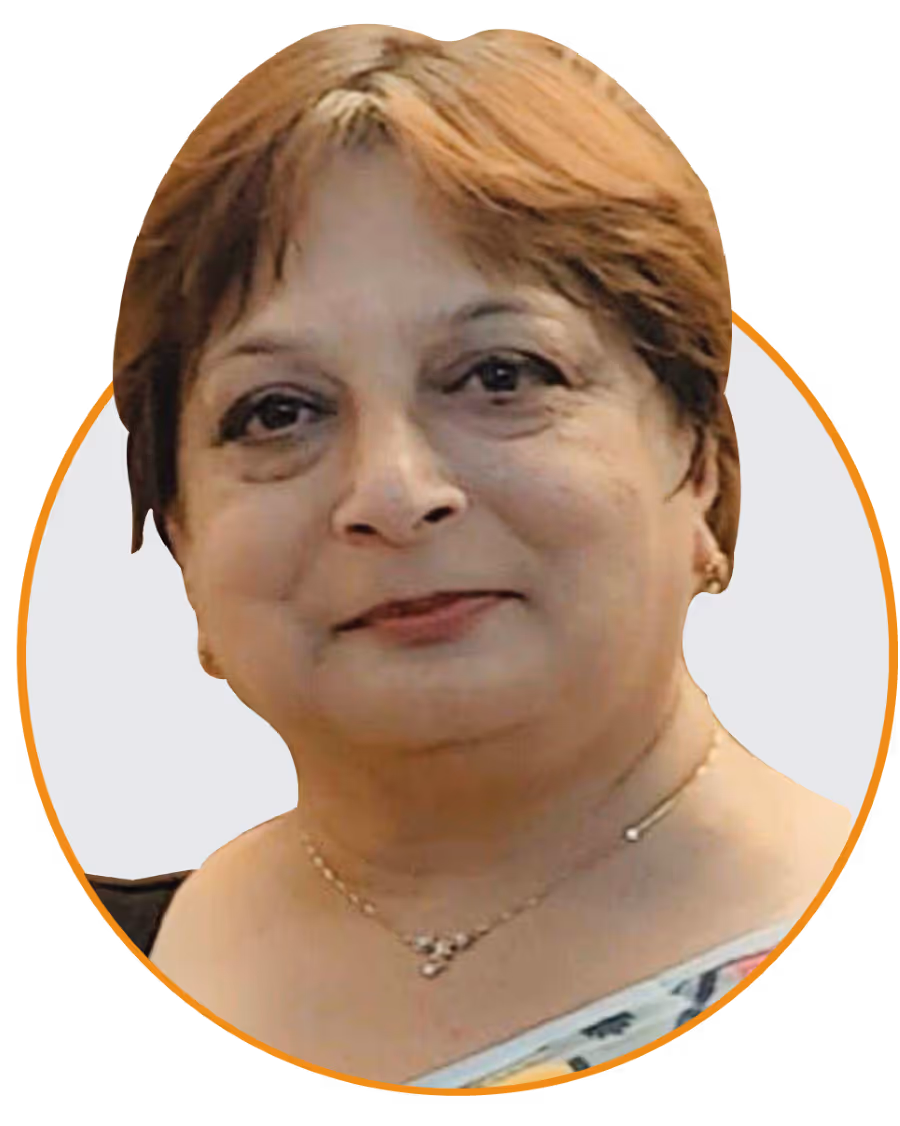 Portrait of a middle-aged woman with short brown hair, wearing a necklace and a light saree with a floral pattern.
